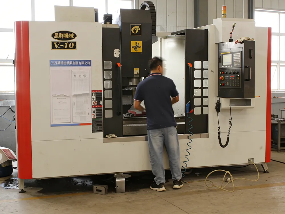 CNC machining process showing operator working on precision metal parts using industrial CNC machine