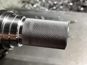 Knurling pattern on metal shaft showing diamond knurling surface finish detail