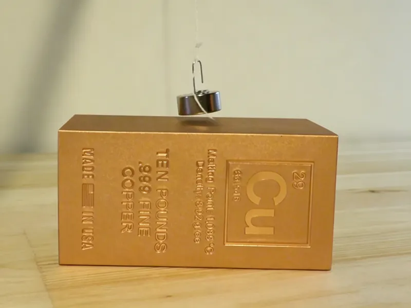 Is Copper Magnetic test showing a magnet above a copper block