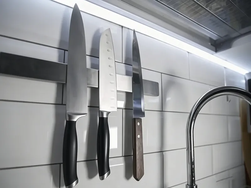 Stainless steel kitchen knives in a humid indoor environment near a sink