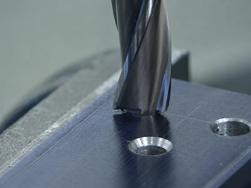 CNC end mill machining a flat bottom hole feature in a metal block