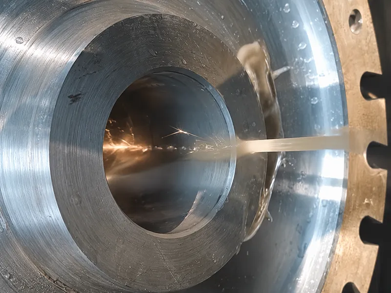 CNC wire EDM machine precisely cutting a circular metal piece with coolant
