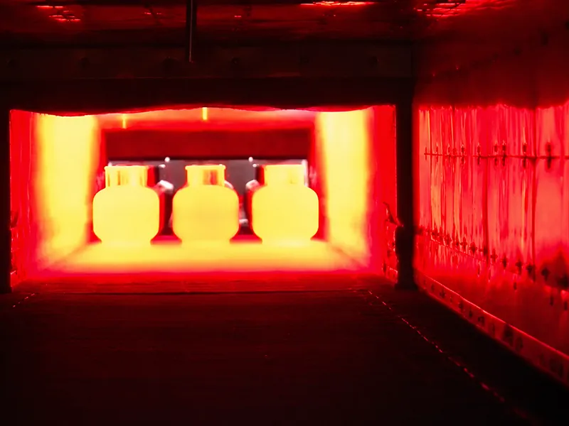 Heated metal parts glowing inside an industrial furnace during heat treatment