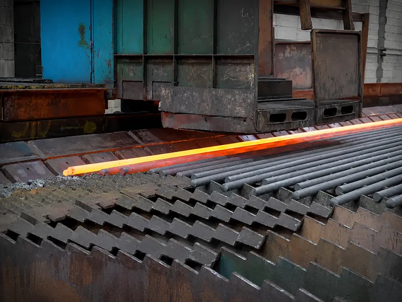 Hot rolled mild steel bars moving through an industrial steel production line