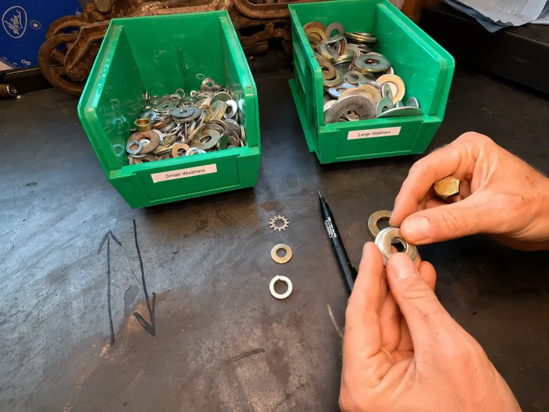 Small and large metal washers sorted in bins for fastener selection and assembly