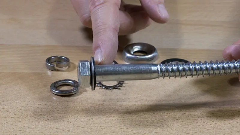 Washer installed under a nut on a threaded bolt to distribute fastening load