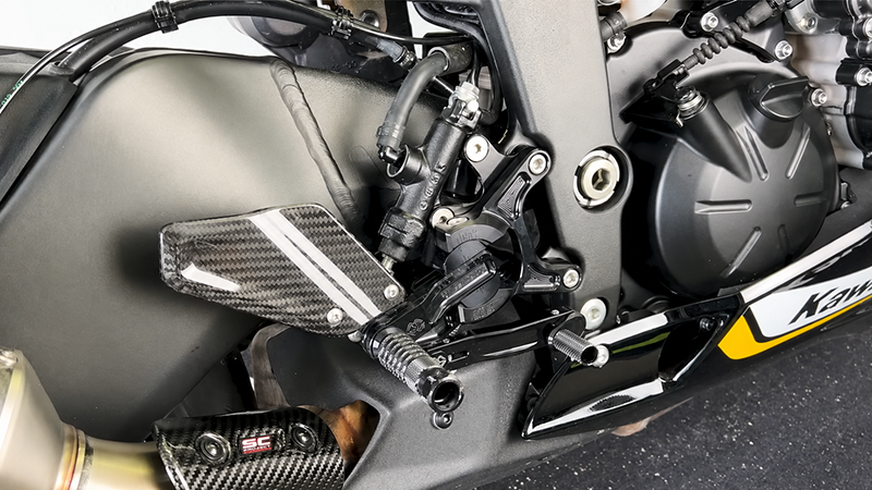 Custom motorcycle rearset and footpeg components mounted on a sport bike