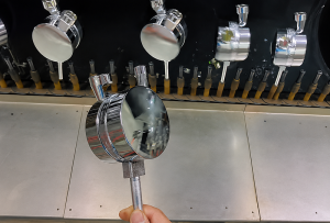 Worker inspecting the reflective chrome finish on a coated plastic component