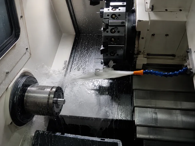 CNC Coolant spraying toward the cutting area inside a turning machine