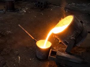 Molten iron being poured from a furnace crucible during high-temperature metal casting