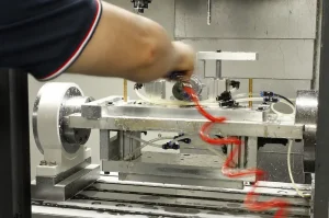 Operator working on a fixture inside a CNC machine, shown in a guide to material machinability.